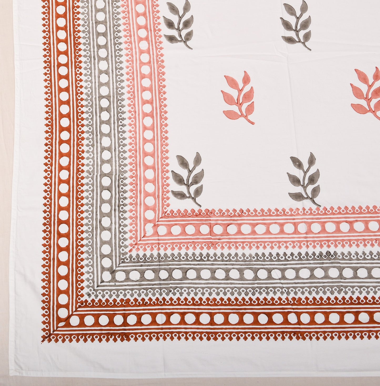 Bedsheet with floral and border patterns on a white background