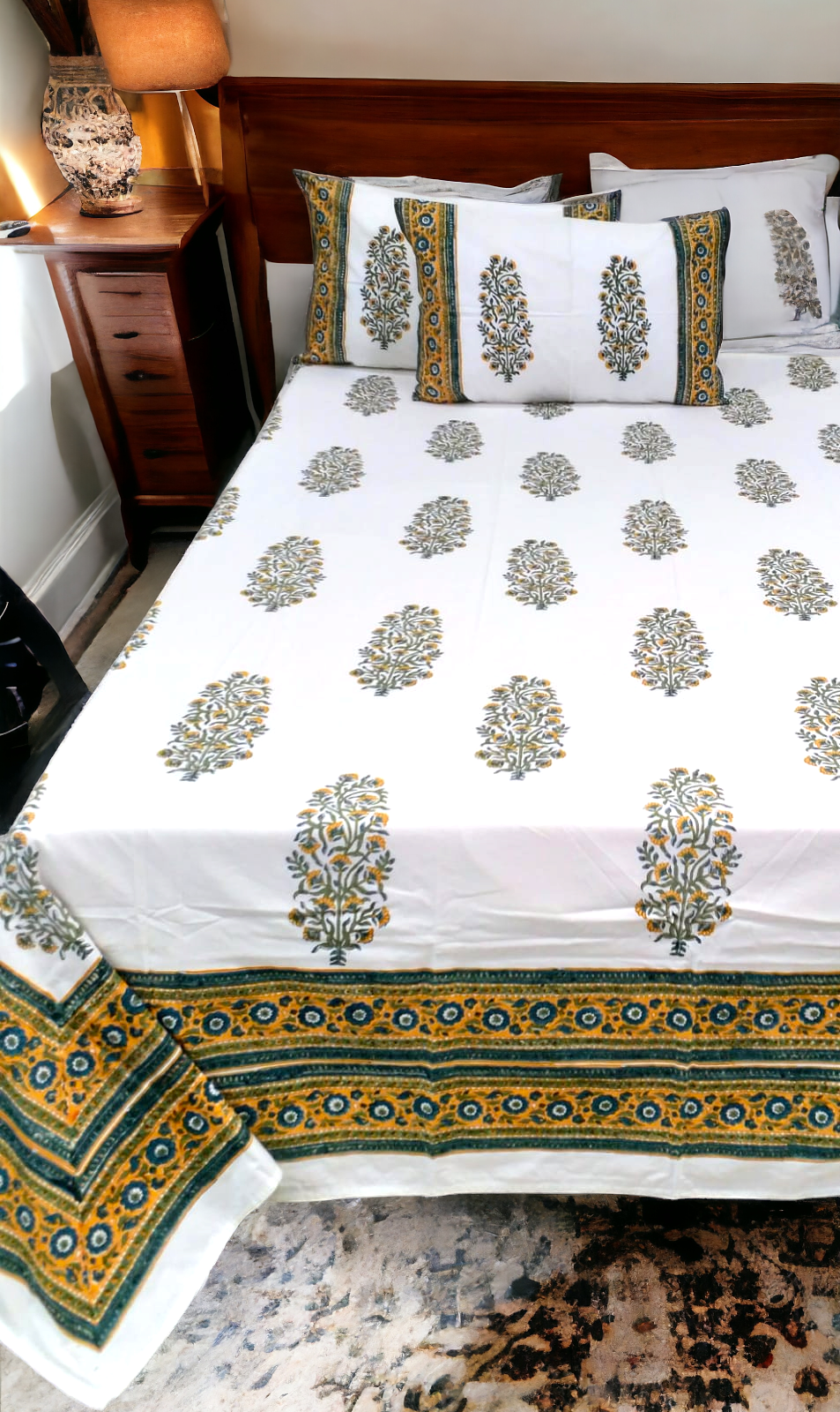 Decorative bedspread with floral patterns on a bed in a bedroom setting.