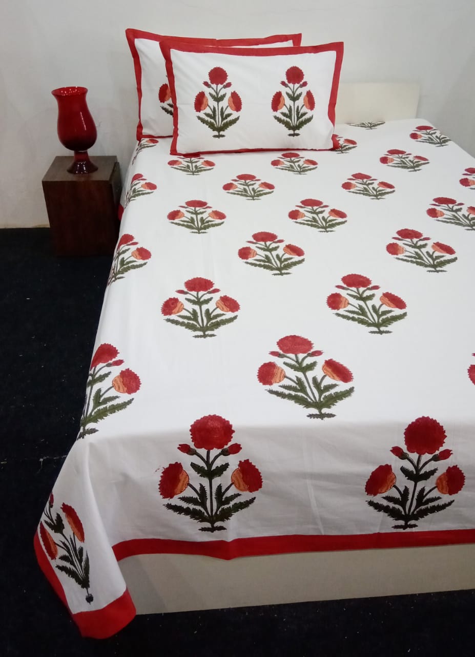 Floral patterned bedspread with matching pillows on a bed in a room setting.
