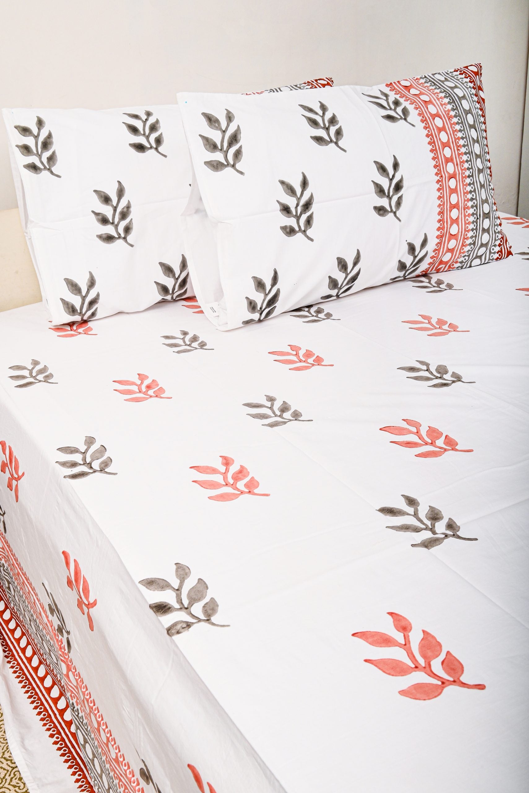 Floral patterned bed sheet set on a bed with white background