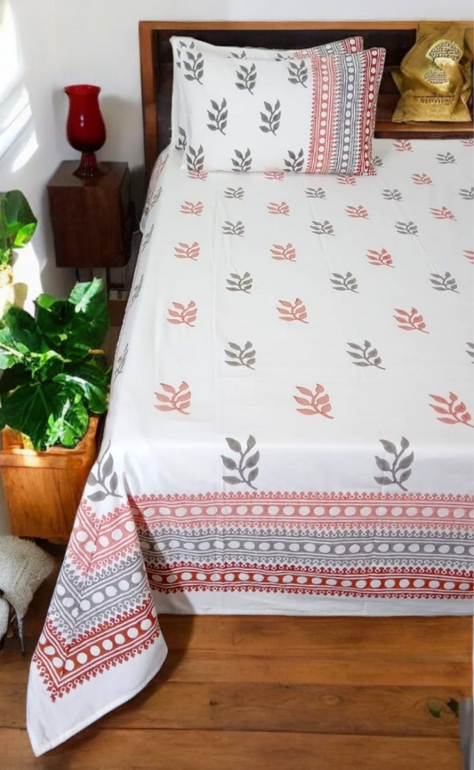 Bed with a floral patterned bedspread in a bedroom setting