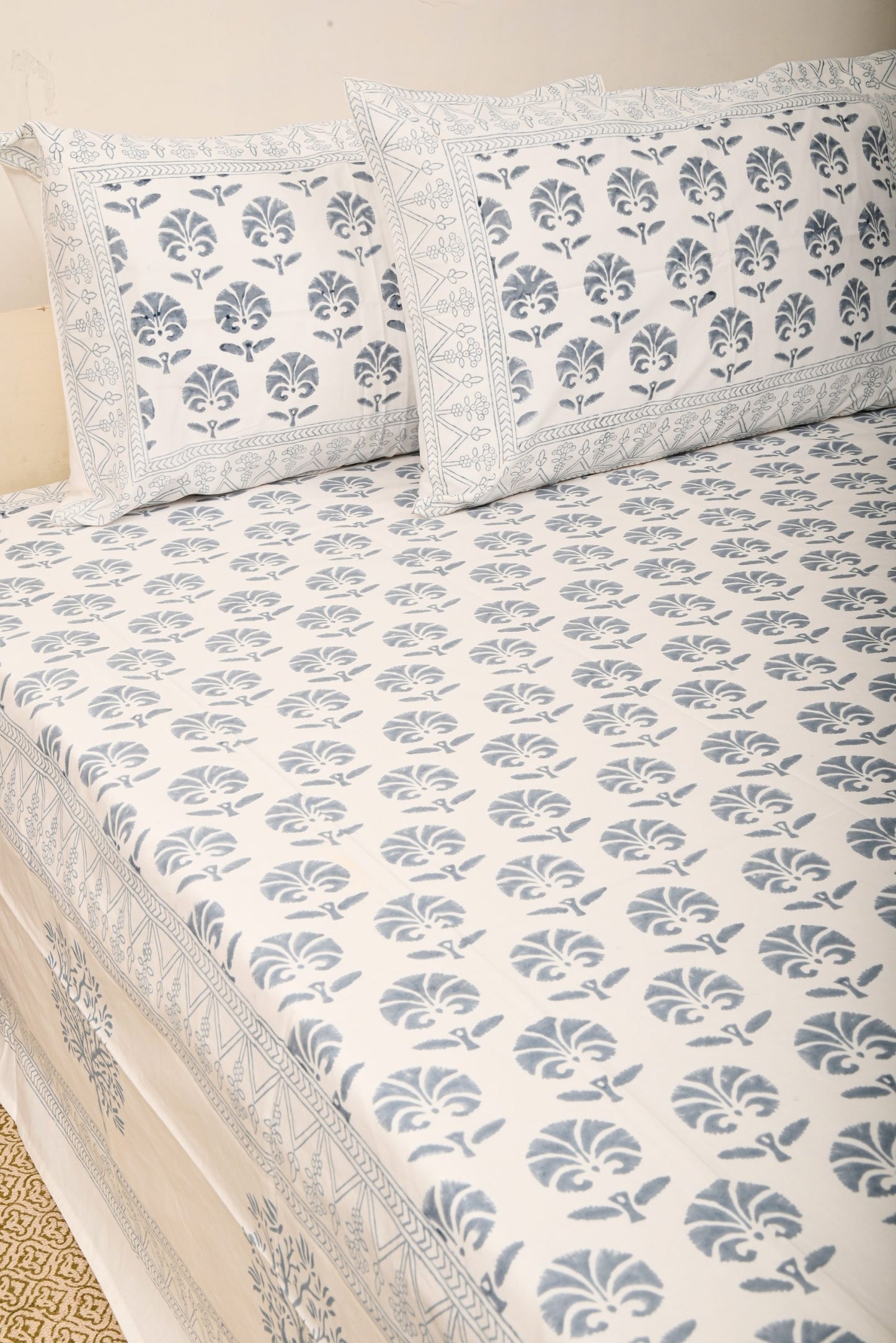 Floral patterned bedspread with matching pillows on a beige background