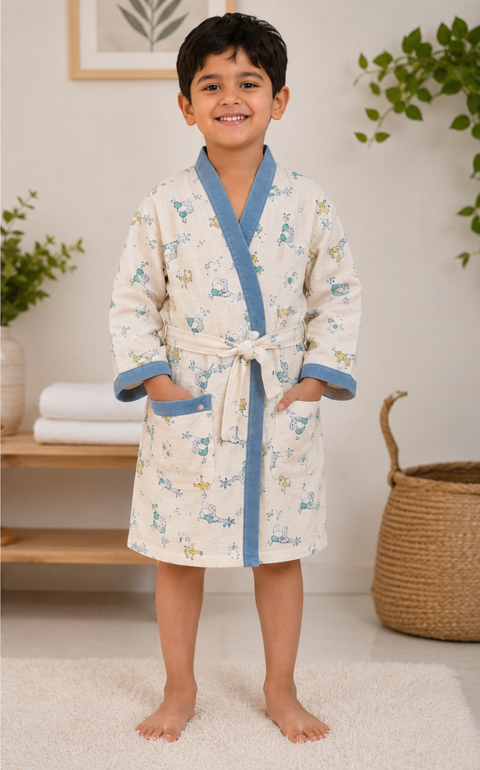 Child wearing a floral robe with blue trim in a room with plants and shelves.