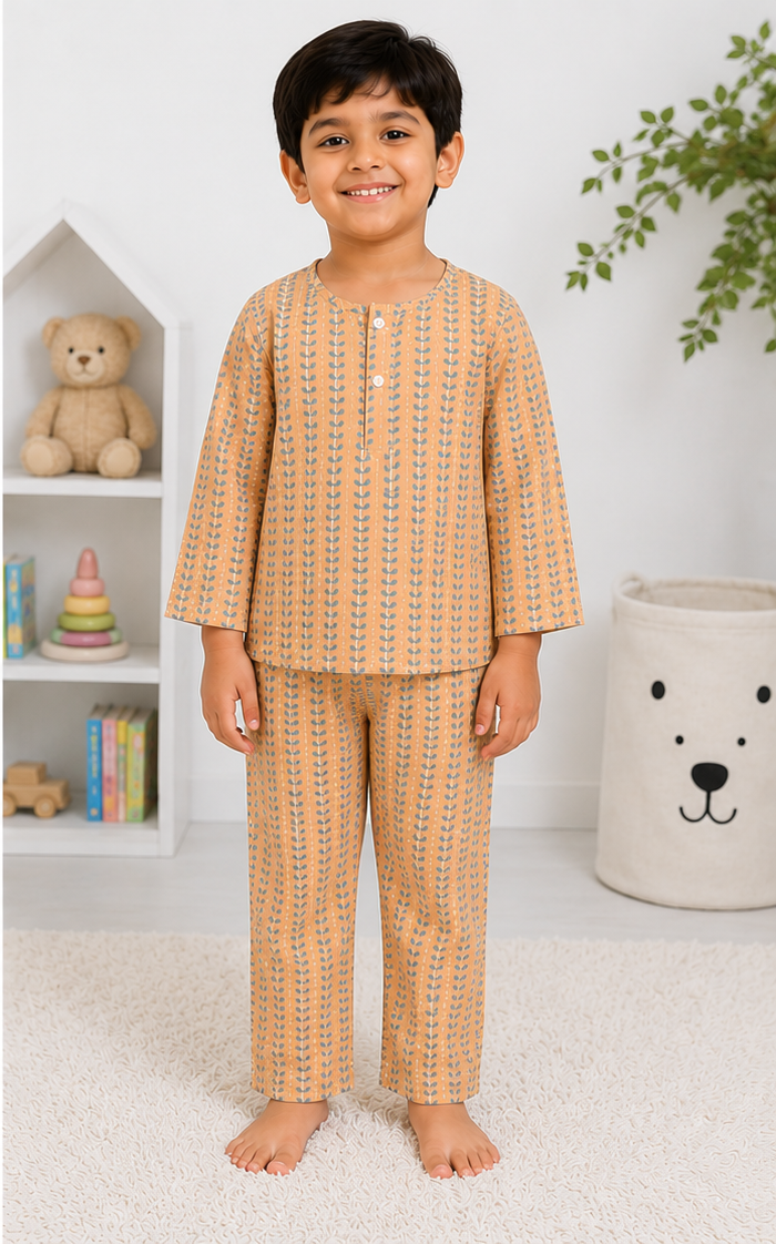 Child wearing a patterned pajama set in a room with a teddy bear and books.